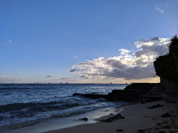 Makalei strand met golven lapping, lava rotsmuur en boten op th — Stockfoto