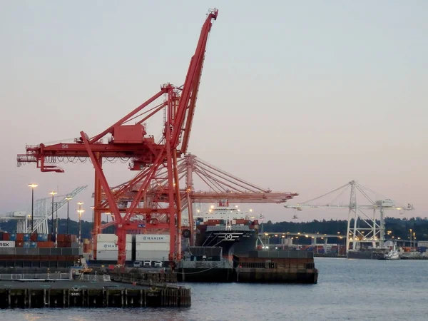 Red and White Cranes unloaded cargo at dusk — Stock Photo, Image