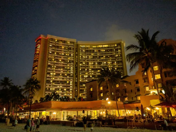 La gente ve los hilanderos de fuego en la playa de Waikiki al anochecer frente a — Foto de Stock
