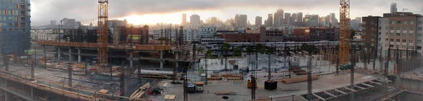 Sunset through the clouds at High-rise Construction site — Stock Photo, Image