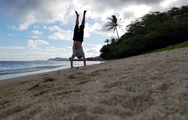 Hombre Handstand en la playa como ola rollo en la orilla —  Fotos de Stock