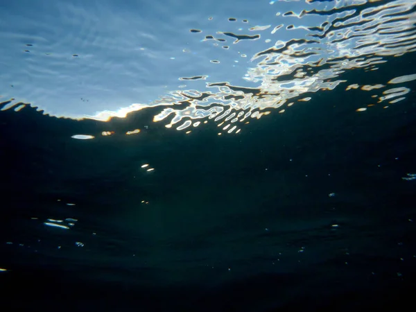 Su dalgalanmalar ile mavi gökyüzünde okyanus suyu bakarak — Stok fotoğraf