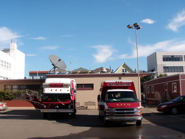 Красная пожарная машина SFD и Ambulance Van припарковались у пожарной станции — стоковое фото