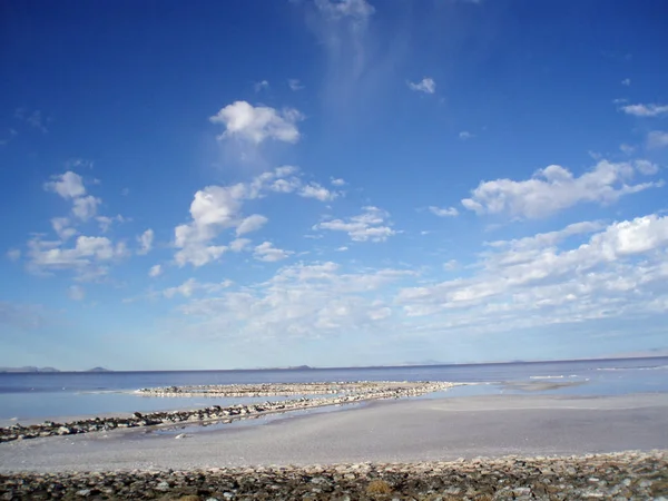 Espiral molhe e céu visto da costa rochosa — Fotografia de Stock