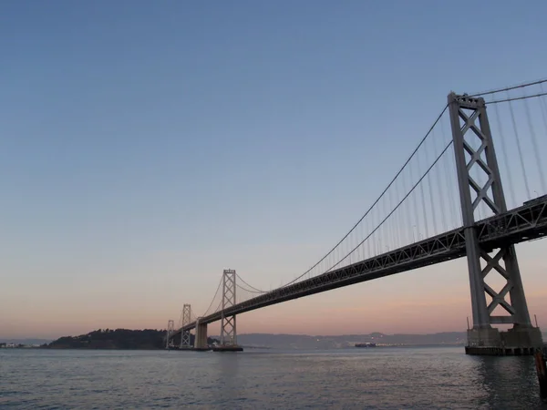 Lado de San Francisco del Puente de la Bahía al anochecer — Foto de Stock