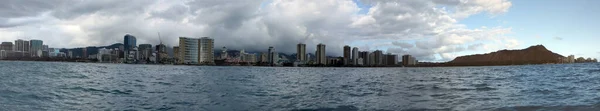 Panoramic of Waikiki Hotels and Diamond Head Crater during the day along the shore seen from the ocean on Oahu, Hawaii.