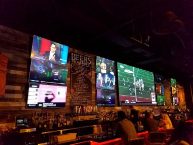 Honolulu - 29 Eylül 2017: İnsanlar Ala Moana Alışveriş Merkezi 'ndeki Lucky Strike Honolulu' nun içindeki Bar 'da NFL Football ve diğer spor kanallarını izliyorlar.