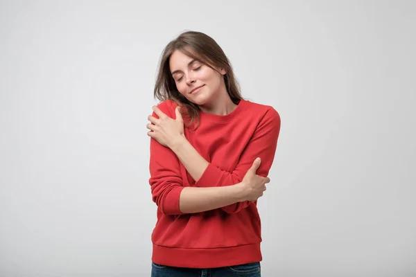 Retrato de uma menina bonita em camisa vermelha abraçando-se . — Fotografia de Stock