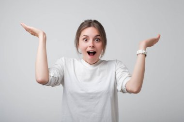 Heyecanlı ve mutlu iyi haber bilmek Avrupa kadında genç ve güzel beyaz t-shirt.