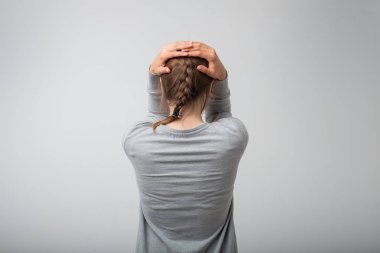 Genç kadın ayakta ağlıyor, arkadan görünüm