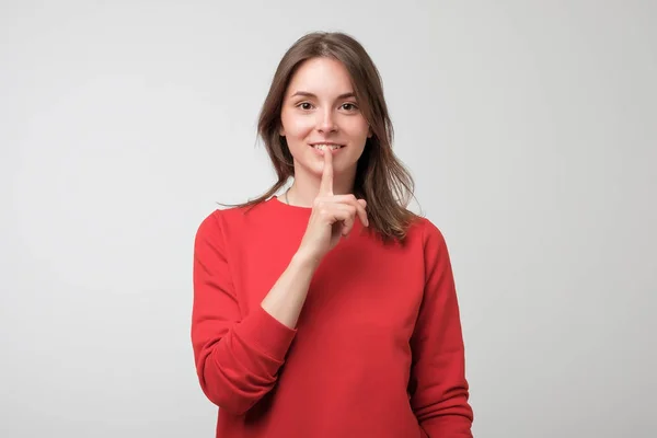 Красива Європейська жінка в червоних pulover, показуючи мовчання знак — стокове фото