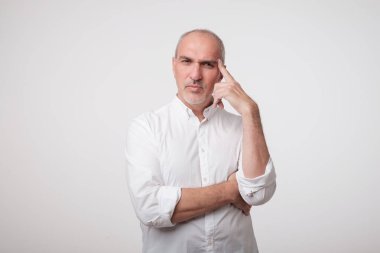 Olgun beyaz adam seyir stüdyo portre kadar düşünceli düşünme.