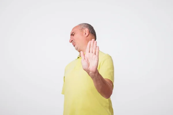 Зрелый Мужчина Жёлтой Рубашке Показывает Знак Стоп Рукой Отрицать — стоковое фото