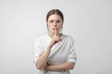 Beyaz t-shirt gösteren sessizlik tabelada beyaz arka plan güzel Avrupa kadın