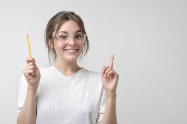 Gözlük ve beyaz t-shirt bir fikir çok heyecanlı seyir gösteren kadın beyaz öğrenci. Kolej veya üniversite eğitimi kavramı