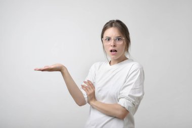 Şok şaşkın genç elleriyle bir şeyler gösteriyor. Boşaltmak metin veya reklam için. Bilgi veya teklif ile karışık.