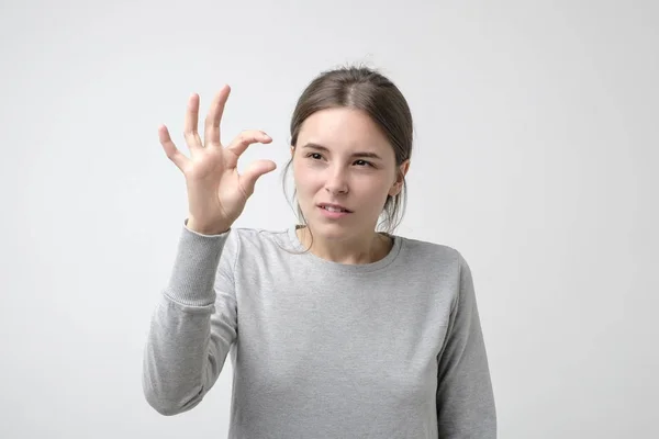 Pěkně Zmatená Dívka Ukazuje Něco Neviditelné Prsty Malé Množství Důležitých — Stock fotografie