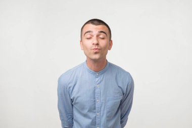 Latin yakışıklı öpülmek için hazır. Dikey gri arka plan üzerine kapatın. Dudaklarından odaklanmak.