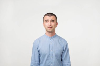 Şüpheli bir gencin mavi gömlekli kapatın. Ne yapacağımı emin değilmiş. Karar şüphe etmek. Hoş olmayan bir durum çıkış yolunu bulun