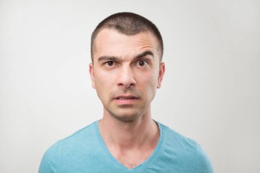 Sıkı ifade ile latin ciddi adam portresi yakından doğrudan kameraya kendine güvenen bir bakışla, yükseltir kaş görünüyor. Şaşkın yüz duygu