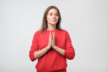 Gri arka plan üzerinde izole bir şey komplo kurnaz, entrikacı genç ve güzel kadın portresi portre.