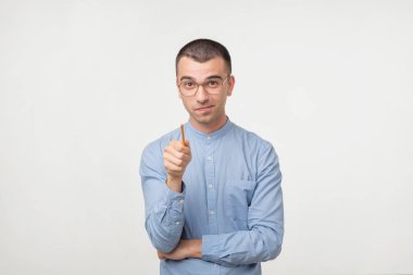 Mavi gömlekli genç adam bir fikrim var. Kalem kamera ile işaret ediyor. Ortağına iyi tavsiyelerde