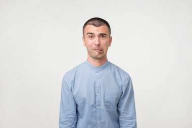 Şüpheli bir gencin mavi gömlekli kapatın. Ne yapacağımı emin değilmiş. Karar şüphe etmek. Hoş olmayan bir durum çıkış yolunu bulun