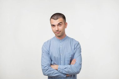 Mavi gömlek geçerken el ve göz kamera mutlu moda yakışıklı adam portresi. O emindir. Kaş yukarı hareket