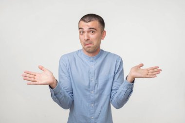 Portre portre genç adam omuzlarında shrugging. Kavram bilmiyorum. Beden dili