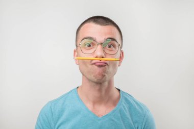 Sorunu çözmek çalışan genç Avrupa adam. Burun ve ağız arasında kalem tutuyor. Eğitim almak kavramı