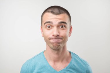 Avrupa adam mütevazı ve utandım, gri arka plan üzerinde izole. O kamera utangaç ve seyir ile şüphe yoktur