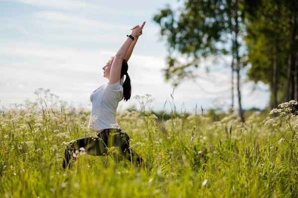 Mujer joven practicando yoga al aire libre en el parque . — Foto de Stock