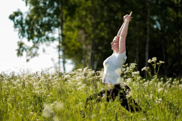 Молодая женщина практикует йогу на открытом воздухе в парке . — стоковое фото