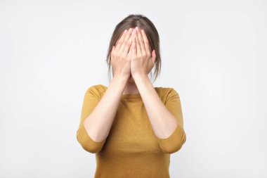 Genç iş kadını yüzü, studio fotoğraf gri bir arka plan üzerinde izole gizler