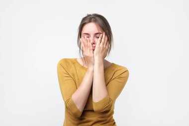 Gözleri kapalı başını dokunmadan sarı kazaklı genç kadın bitkin.