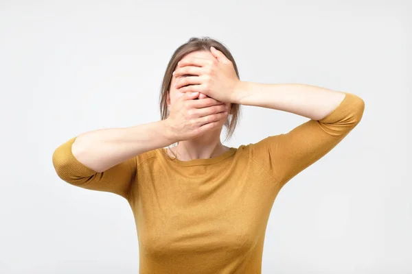 Mladá podnikatelka skrývá její tvář, Foto studio, samostatný na šedém pozadí — Stock fotografie