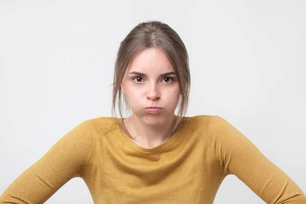 Jonge Europese vrouw in gele trui op zoek met beledigd look, wordt ontevreden met iets — Stockfoto