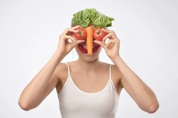 Jovem loira segurando legumes como se fosse seu rosto . — Fotografia de Stock