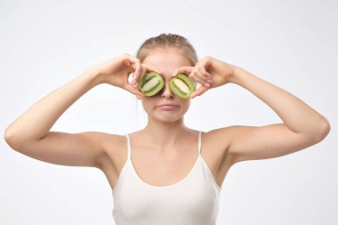 Kivi. Kivi gözleri için tutan sağlıklı meyve komik kadın. Üzgün yüz duygu