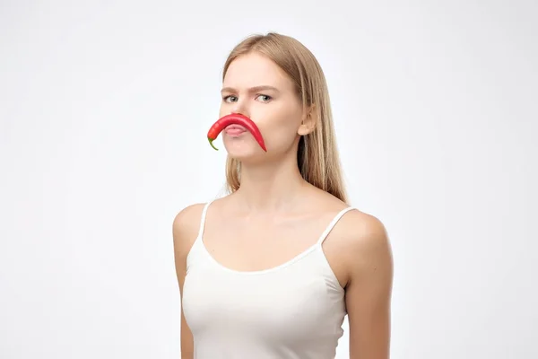 Europeiska unga kvinna som håller red hot chili peppar som mustasch — Stockfoto