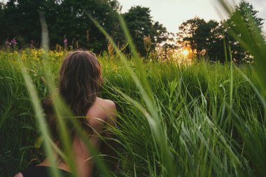 Yeşil taze sunset Bulvarında bakarak yalan genç esmer kadının. Doğa ile birlik kavramı