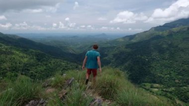 Dağlardaki yürüyüş ve hill kenarına geliyor seyahat adam.