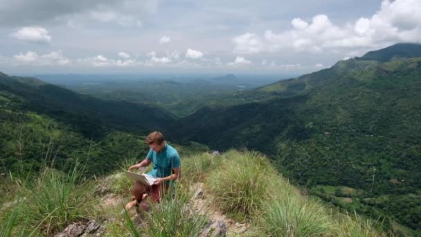 Красивый европейский фрилансер, работающий над ноутбуком на открытом воздухе в горах . — стоковое видео