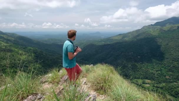 Dobrodružství fotograf s kamerou natáčí stoje v mini Adams peak na Srí Lance. Skvělý pohled z vrcholu. — Stock video