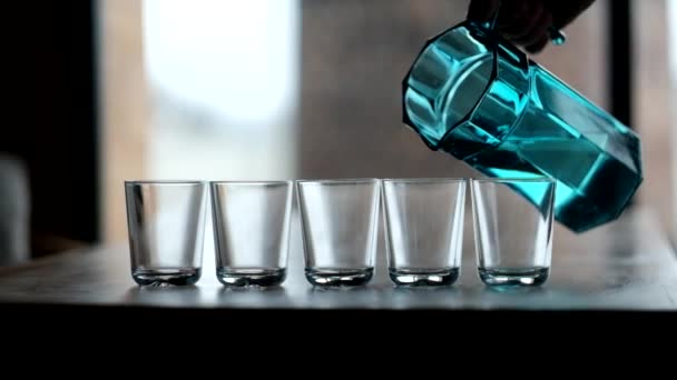 Água que despeja de um jarro em um copo — Vídeo de Stock