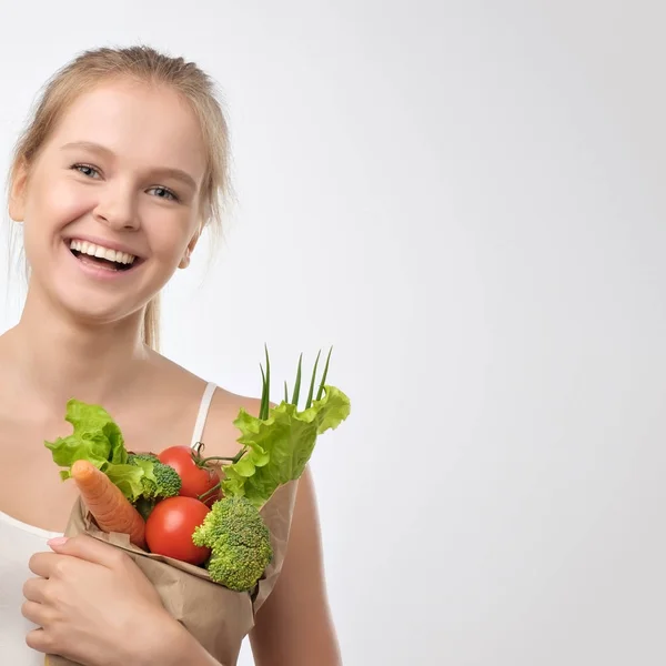 ペーパー買い物袋の新鮮な野菜を保持している若い女性。ダイエット健康的な食事の概念 — ストック写真