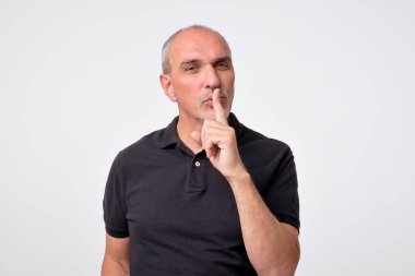 Sessizlik için soran dudaklarında parmak ile genç adam