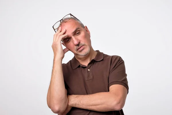 Nahaufnahme Porträt eines nachdenklichen reifen Mannes im braunen T-Shirt. — Stockfoto