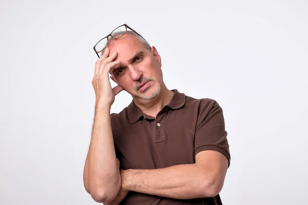 Close-up van portret van peinzende volwassen man in bruin t-shirt. — Stockfoto