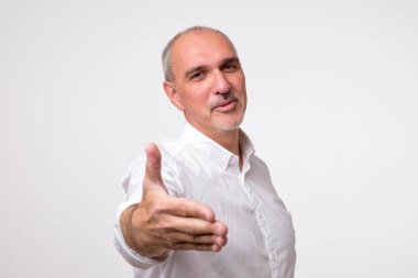 Hoş geldiniz kavramı vardır. Hoş geldiniz işareti işaret ve gülümseyen Beyaz tişörtlü neşeli olgun adam